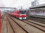 Die Fahrzeuge des Keihin Kyûkô-Konzerns, Serie 1500: 166 Wagen wurden zwischen 1985 und 1993 für Pendlerzüge gebaut und zu 4-, 6- und 8-Wagenzügen zusammengesetzt. Die Züge können auch auf der U-Bahn verkehren. Im Bild überholt ein langer Zug mit Wagen 1719 an der Spitze als Eilzug einen am Bahnsteiggeleise wartenden Lokalzug. Minami Ôta, 25.Juni 2011. 