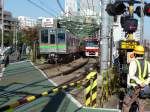 Fremde Züge auf der Keikyû-Linie: Die Chiba New Town–Bahn. Diese Bahn gehörte ursprünglich der Gesellschaft für Wohnungsbau und Stadtentwicklung, die grosse Ueberbauungen in der Präfektur Chiba nordöstlich von Tokyo vorantrieb. Seit 2004 ist die Chiba New Town–Bahn eine Tochtergesellschaft des Keisei-Konzerns und besitzt Anlagen auf der Strecke Richtung Narita-Flughafen und 5 Züge, aber kein eigenes Personal. Auch die Chiba New Town-Bahn erreicht den Keikyû-Konzern via Städtische U-Bahn Tokyo (Asakusa-Linie). Im Bild der von der  Gesellschaft für Wohnungsbau und Stadtentwicklung  stammende Achtwagenzug (Baujahr 1984) mit den Wagen 9011-9018; der andere gleichartige Zug ist ausgemustert. Der neue Keikyû-Zug 1307 (Serie 1000, Baujahr 2012) kommt entgegen. Tokyo-Shinagawa, 28.Oktober 2011. 