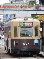 Wagen 907 der Hiroshima Strassenbahn als Linie 7 am 09.11.2010 in der Haltestelle  Tate Machi .