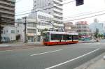 Matsuyama Strassenbahn, Serie 2101-2110: Wagen 2106 an der Kreuzung mit der Iyo-Bahn, denen der Strassenbahnbetrieb von Matsuyama gehrt.