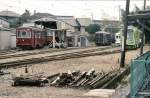 Serie 3100: Wagen 3102 steht im Betriebswerk vor der Werkstatt, in der ein Wagen aus Tokyo aufgebockt ist.