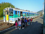 KIHA 37 2 (mit KIHA 38 1) ist mit einer Schar Kinder im Dorf Kururi angekommen, 27. November 2009 