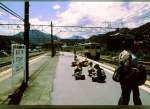 Serie 115 des zentraljapanischen Hochlands: An einem heissen Sommertag kehren Jugendliche nach einer Wandertour nach Tokyo zurück. Ein Zug mit motorisiertem Frontwagen KUMOHA 115-316 fährt in die Station Ôtsuki ein, in Richtung Tokyo. 27.Juli 1997. 
