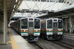 Die zwei elektrotriebzüge serie 211 (Untergruppe 3000) warten auf die Abfahrt: Fahrtnummer 139M Shin'etsu linie Nahverkehrszug nach Yokokawa, und 641M Ryômô linie nahverkehrszug nach Isesaki. am bahnhof Takasaki, 29.04.2024.