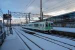 Serie 701 des Bezirks Morioka - im Schatten des Shinkansen: Neben dem imposanten Shinkansen-Bahnhof von Morioka fährt früh am Morgen Zug 701-1026 aus. Er trägt noch den Anstrich des Bezirks Sendai, wo er früher beheimatet war. 16.Februar 2013. 