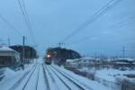 Serie 701 des Bezirks Morioka: Im ersten Morgengrauen wirbelt ein Zug nördlich von Hanamaki den Schnee hoch, 13.Februar 2013.