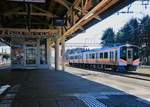 Die Nordwestküste Japans, am Japanischen Meer: Die Hauptlinie Niigata - Akita, Bahnhof Murakami. Hier am nördlichen Ende der Gleichstromstrecke ab Niigata steht Lokalzug Serie E129 (Nr. 113). Der Bahnhof verkündet:  Willkommen in Murakami, der Stadt des Lachses und der heiss sprudelnden Quellen  (Gut Essen und sich im heissen Wasser entspannen sind mit Abstand die Hauptattraktionen des japanischen Inland-Tourismus). 18.März 2019  