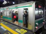Serie 205: Saikyô-Linie - Die Präzision beim Anhalten ist erstaunlich; erst wenn das hintere Schaffnerabteil millimetergenau auf der Zahl 11 (für einen 11-Wagenzug) steht, öffnet die Schaffnerin die Türen. Hier checkt sie, dass die Türen frei sind zum Schliessen. Wagen KUHA 204-106, Tokyo-Shinjuku, 28.November 2009. SAIKYÔ-LINIE 