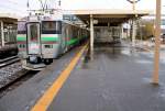 Serie 733, die neuen S-Bahnzüge für die Agglomeration Sapporo auf Hokkaidô. Treppenaufgänge und Wartepunkte auf den Bahnsteigen müssen gut gegen den eisigen Wind und Schnee geschützt sein. Zug 733-3104 ist vom Flughafen gekommen und wartet nun auf Abfahrt nach Sapporo. Minami Chitose, 25.Oktober 2015. 
