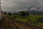 Das nahende Ende des Lokalverkehrs auf Hokkaidô. In der Hochebene von Furano fahren die beiden Triebwagen KIHA 40 1752 und KIHA 40 1778 in die Station Nunobe ein. Die gewaltigen Vulkanketten verbergen sich hinter Sturmwolken. 28.Juli 2016. NEMURO-HAUPTLINIE