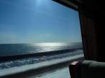 KIHA 283: Blick aus dem Fenster eines Intercity-Zuges Serie 283 auf den eiskalt schimmernden Pazifik an der Südostküste von Hokkaido bei Onbetsu unweit von Kushiro.