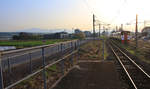 JR Kyûshû Serie 815. Direkt vor der aufgehenden Sonne fahren die beiden Züge 815-11 und 815-14 aus dem Hinterland der Stadt Kumamoto Richtung Stadt. Im Hintergrund das Vulkanmassiv des Aso-Vulkans. Haramizu, 2.April 2018  