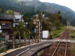 Der KIHA 120-202 der Kuzuryû-Linie im Spiegel: In Ushigahara hält der Wagen vor einer Bauernhausgruppe mit Bäumen voller Kakifrucht. 3.November 2008.