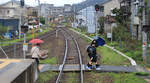 Die Chizu Kyûkô Privatbahn im Spiegel: Schüler sind aus dem Zug ausgestiegen, und der rote Schirm spiegelt sich vor Triebwagen 3504 + 3503 im Bahnsteig-Spiegel.