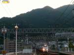 Serie 683: Im letzten Abendlicht kommt in Ôtsukyô ein langer Zug aus 3+3+6 Wagen von Osaka und Kyoto her durch den langen Tunnel zum Biwa-See gefahren.
