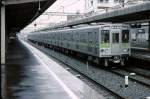 Grunddaten zur Städtischen U-Bahn Tokyo: Die Stadt Tokyo betreibt 4 U-Bahnlinien (in 1067mm-, 1372mm- und 1435mm-Spur). Die Gesamtlänge beträgt 106,7 km. Die meisten Linien führen über die Endpunkte hinaus weiter auf andere Bahnen, deren Züge im Naturalausgleich auch die U-Bahn befahren. Die Städtische U-Bahn Tokyo hat ein eigenes Tarifsystem, was beim Umsteigen von und zur Tokyo Metro oft für Verwirrung sorgt. Die 4 Linien heissen: Asakusa-Linie, Mita-Linie, Shinjuku-Linie, Ôedo-Linie. Bild: Ein Zug (Nr. 10-030) der Shinjuku-Linie in Sasazuka, 14.April 1980. 
