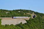 Wiederum 1141 376 kommt gerade mit dem 4604 Ogulin - Rijeka aus dem Tunnel und verliert Permanent an Höhe Richtung Küste. Aufgenommen bei Meja, 19.07.2015