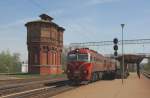 Die litauische Doppellok 2M62 1161 ist am 29.4.2012 mit einem schweren Kesselwagenzug in Richtung Kaunas unterwegs und passiert gerade den   imposanten Wasserturm im Bahnhof Kaisyadoris.