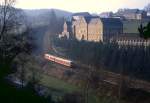 Luxembourg Tw 211 ist am 31.03.1990 mit Zug 1928 auf den letzten Kilometern vor seinem Ziel Troisvierges unterwegs. Im Hintergrund das Kloster Fnfbrunnen bei Sassel.