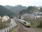 CFL 3004 zieht den Interregio mit belgischen Wagen  von Liege nach Luxemburg durch Michelau. Im Hintergrund liegt die Burg Bourscheid. 6.4.2013