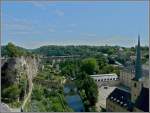 In Luxemburg ist nicht die Bahn Weltkulturerbe, sondern der historische Kern der Altstadt, sowie einige der erhaltenen Festungsbauten. 

Links im Bild sieht man den Bockfelsen, der auch als die Wiege Luxemburgs bezeichnet wird. Hier errichtete der Ardennergraf Siegfried im Jahre 963 eine Burg, die Lucilinburhuc, welche als Grundlage fr die sptere Stadtgrndung angesehen wird. 

Rechts ist die Abtei Neumnster zu sehen, welche von 1869-1984 als Gefngnis diente und heute ein Kulturzentrum bildet. Neben dem Turm der Kirche Sankt Johann ist eines der grten Tore, die Dinselpforte aus dem 15. Jahrhundert zu sehen. 

Der Fluss in der Mitte des Bildes ist die Alzette mit dem kleinen Steg  Stierchen  und einem von mehreren Trmchen, daneben erkennt man die  hngenden Grten , wo sogar Wein angebaut wird. 

Ach ja, ein Wendezug ist auch noch zu sehen, er berquert den Clausener Viadukt im Hintergrund. 01.08.09 (Jeanny)