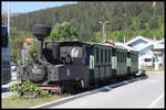 Auf der breiten Zufahrtstraße zum Bahnhof Kicevo in Mazedonien steht auf dem Mittelstreifen dieser Schmalspurzug mit einer ehemaligen Heeresfeldbahn Lokomotive.