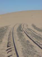 Die Namib-Wüste wie sie lebt! Die Wüstenbahn wie sie ist! Die Südbahnstrecke nach Lüderitz verschwindet unter einer Wanderdüne.