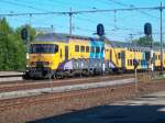 Ein mit Graffiti beschmierter Triebwagen der NS fhrt mit einem D-zug nach Amsterdam Centraal ein.
Weesp, 20.05.2004.