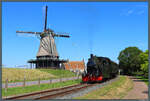 Lok 26 der Stoomtram Hoorn - Medemblik (SHM) dampft am 26.08.2026 an der Windm�hle  De Herder  in Medemblik vorbei.
