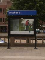 Hier noch zum Abschluss ein Bahnhofsschild inklusive Werbeplakat im Bahnhof von Enschede.