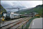 Fl�msbana VY El18 2252 am 04.06.2026 im Bahnhof Fl�m. Im Hintergrund liegt ein Kreuzfahrtschiff im Hafen des Dorfes.