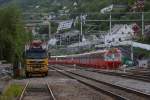 Am 10.06.2012 stehen im norwegischen Bahnhof Voss ein Zweiwegefahrzeug  fr Oberleitungsreparaturen und der Nahverkehrstriebwagen 69 651.