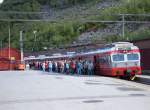 69 669 in modernen Farbdesigne nach Bergen am 14.06.2006 im Bahnhof Myrdal, Passagiere vom Kreuzfahrschiff Arielle, die mit der Flambahn nach Myrdal gekommen sind, drngen zur Weiterfahrt nach Voss in