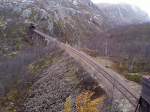 Die Norddalen-Brcke von einen anderen Standpunkt, hinter dem gegenberliegenden Tunnel kommen die beiden Trassen wieder zusammen, Brcke und Tunnel sind durch Gittertore verschlossen.