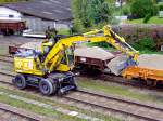 Zweiwegebagger (LIEBHERR_900) verfrachtet Sand von einem zum anderen Flachwagen;111007