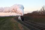 Die tiefstehende Sonne kurz vor ihrem Untergang taucht die Abdampfwolken der NLB 93.1420 und der VdEA 52.4984 in seltsam anmutendes Rosa. Aufnahme vom 09.12.2012 im letztem Bogen vor dem Bf. Hohenau.