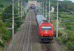 Regionalexpress 2713  Steirisches Vulkanland  dieselt auf der Suedbahn zwischen Gumpoldskirchen und Pfaffstaetten entlang der Weinberge Richtung Feldbach in der Steiermark. Der kleine feine Tunnel im Hintergrund ist der sogenannte  Busserltunnel .
Das Foto ist am 09.08.2008 entstanden.