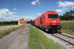 Ein Gterzug passiert den Bahnhof Lackenbach, der auch ein wichtiger Bestandteil der burgenlndischen Draisinentour ist, im gelb gefrbten Gebude wird den Draisinenfahrern Speis und Trank angeboten, Juli 2012