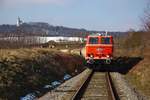 Der stehende Zug mit der 2143.056 an der Spitze kurz nach Karnabrunn. Im Hintergrund einige Weinkeller und katholische Kirche. (25.02.2018)