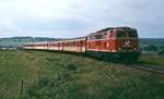 Im Juni 1987 ist die 2143 005-7 mit dem Eilzug von Wien nach Bad Tatzmannsdorf kurz hinter Oberwart unterwegs.