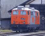 2143 077 steht am 01.April in den RTS Farben vor einem Lokschuppen am Bahnhof Reute in Tirol.