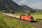 Die ÖBB 1016 037 mit Autotransportwagen auf der Inntalstrecke kurz nach Kufstein, nahe der Ortschaft Langkampfen in Richtung Brenner. Aufgenommen am 28.07.22