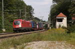 1016 015 der ÖBB vor Güterzug mit Taschenwagen und Lkw-Aufliegern bei der Einfahrt in den Bahnhof Aßling (Strecke München-Rosenheim).
