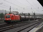 Die 1016 004 mit einem Kesselwagenzug bei Strmenden Regen am 22.08.2009 bei der Ausfahrt aus dem Salzburger Hbf. 