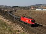 Die 1016 034 mit einem Schienenzug am 15.03.2015 unterwegs bei Haiding.