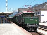 1020.044 (als Vorspann von 1020.042) vor einem Sonderzug beim Halt am Bahnsteig 2 in Wörgl Hauptbahnhof am 20. Mai 2007. Im Hintergrund das Aufnahmegebäude mit dem Zentralstellwerk der Betriebsfernsteuerzentrale Wörgl.