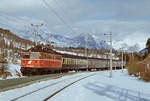 Im Februar 1988 fährt die ÖBB-Lok 1042.634 mit DB-Wagen in 1120 m Seehöhe in den Bahnhof Reith ein.
