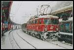 Am 3.02.2005 hat es in Bruck an der Mur heftig geschneit. 1042 007 steht mit einem Güterzug am Bahnsteig 4 und wartet auf die Weiterfahrt.