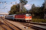 1043 005-6 verlässt Mitte der 1990er Jahre mit dem EC  Mimara  (damaliger Zuglauf Leipzig - Zagreb) den Villacher Hauptbahnhof. Das Foto entstand aus einem parallel fahrenden Regionalzug.