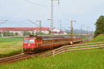 Juli 1988, Wenige Kilometer vor Freilassing fährt ein Zug der ÖBB mit der ÖBB-Lok 1044 081-6 auf der Korridorstrecke bei Straß in Richtung Salzburg.